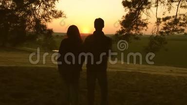一个女人和一个男人旅行，在森林里散步，拥抱和欣赏日落时的风景。 <strong>情侣</strong>旅行者带<strong>背包</strong>旅行